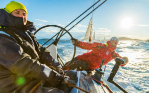 Action image of sailors on helm - Adventure Marine